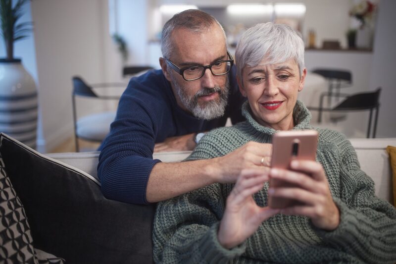 An older couple reviewing their MedibandPlus medical profile together on a phone at home